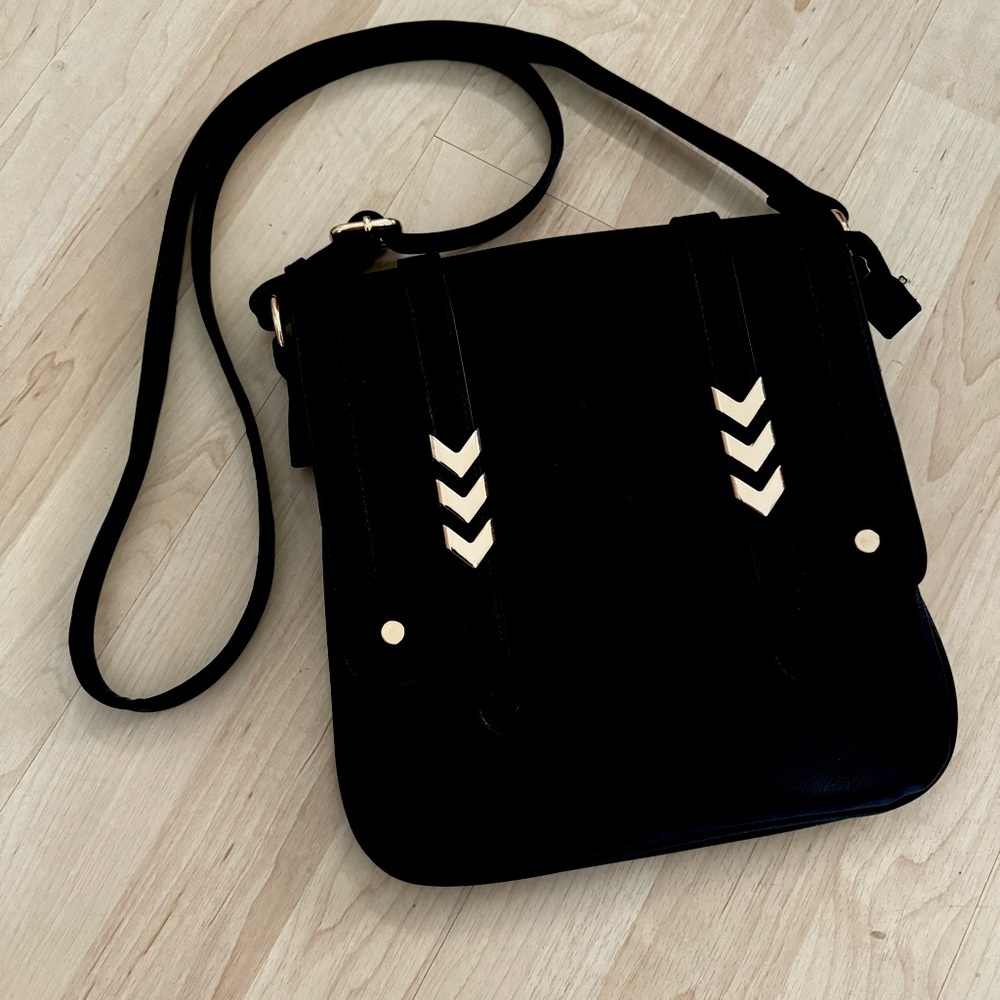 Black vegan leather crossbody purse with gold chevron details, adjustable strap.